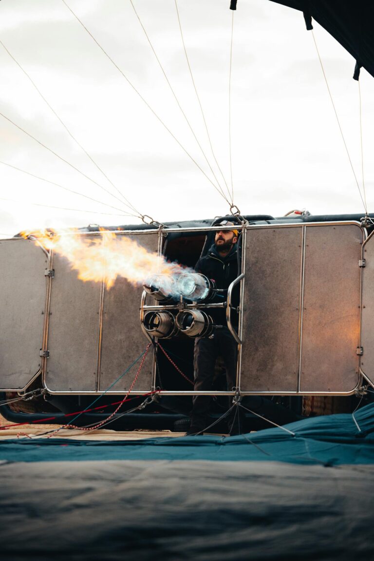 Hot air balloon preparation with flame in Ürgüp, Turkey at sunrise.