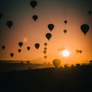 Stunning silhouettes of hot air balloons against a vibrant sunset sky, creating a dreamy atmosphere.