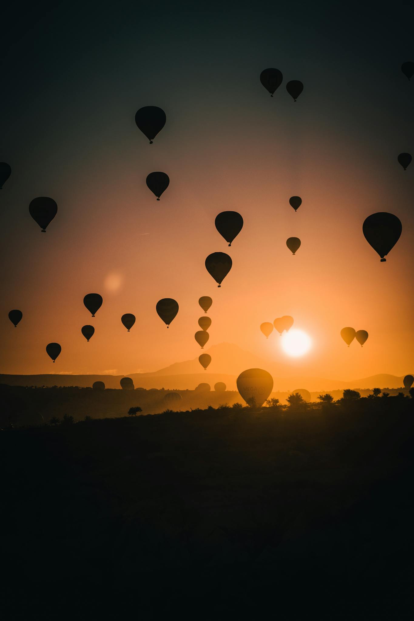 Stunning silhouettes of hot air balloons against a vibrant sunset sky, creating a dreamy atmosphere.